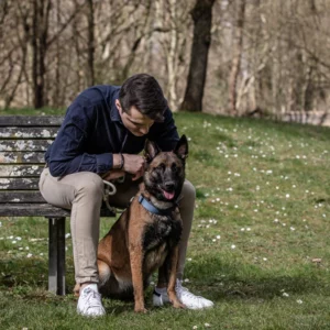 Homme avec son chien assis sur un banc dans un parc. Photo d'un animal